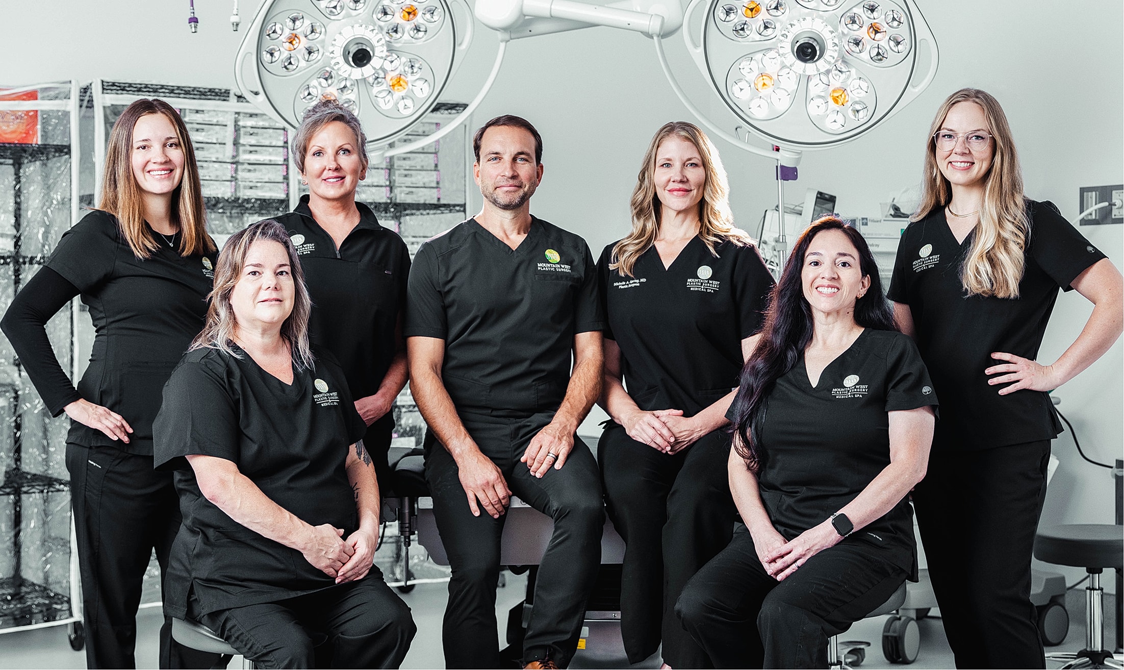 Medical team posing in surgical environment.