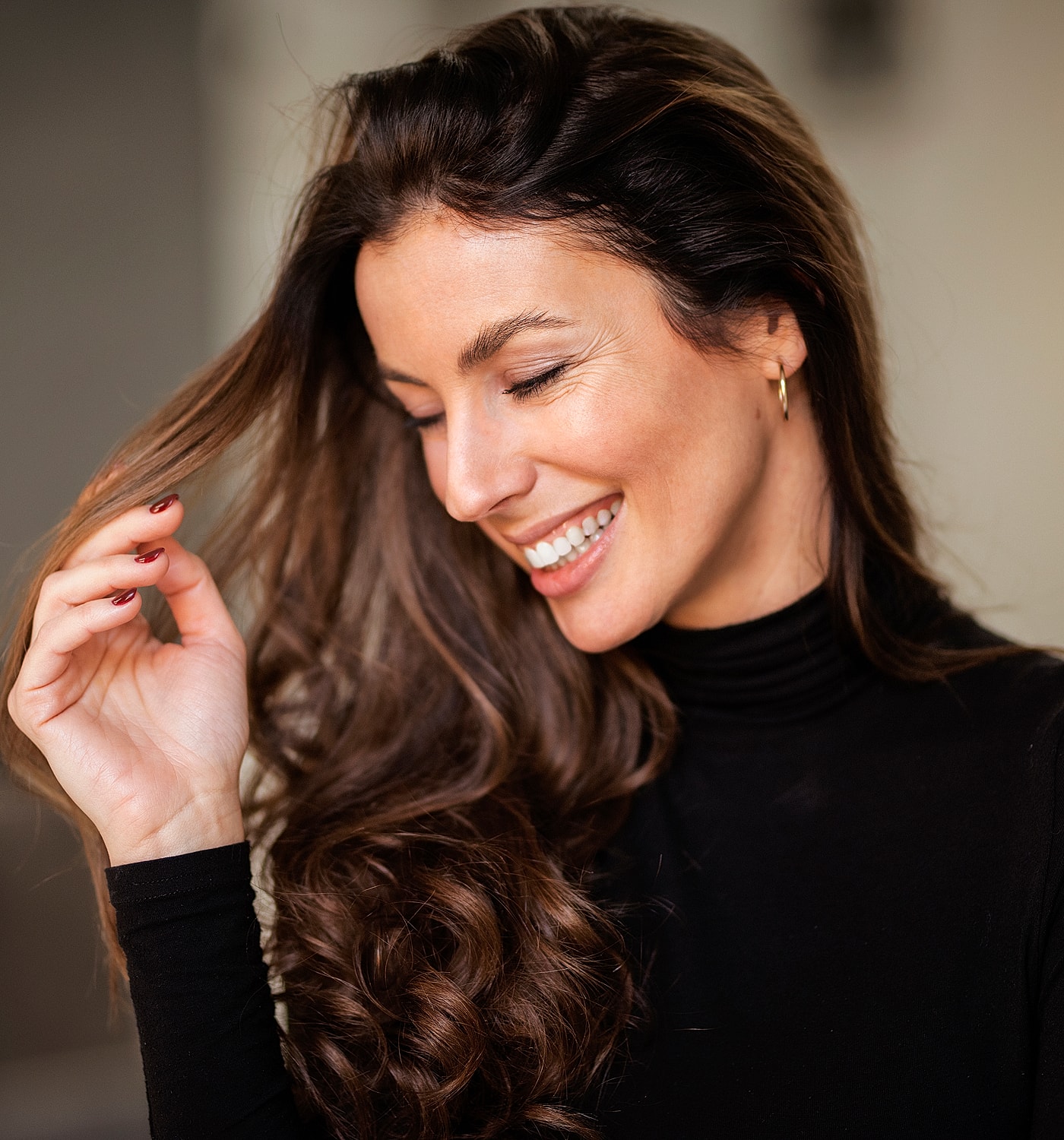 Smiling woman with long, wavy hair.