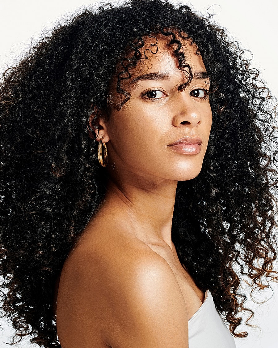 Woman posing in fitted dress against wall.