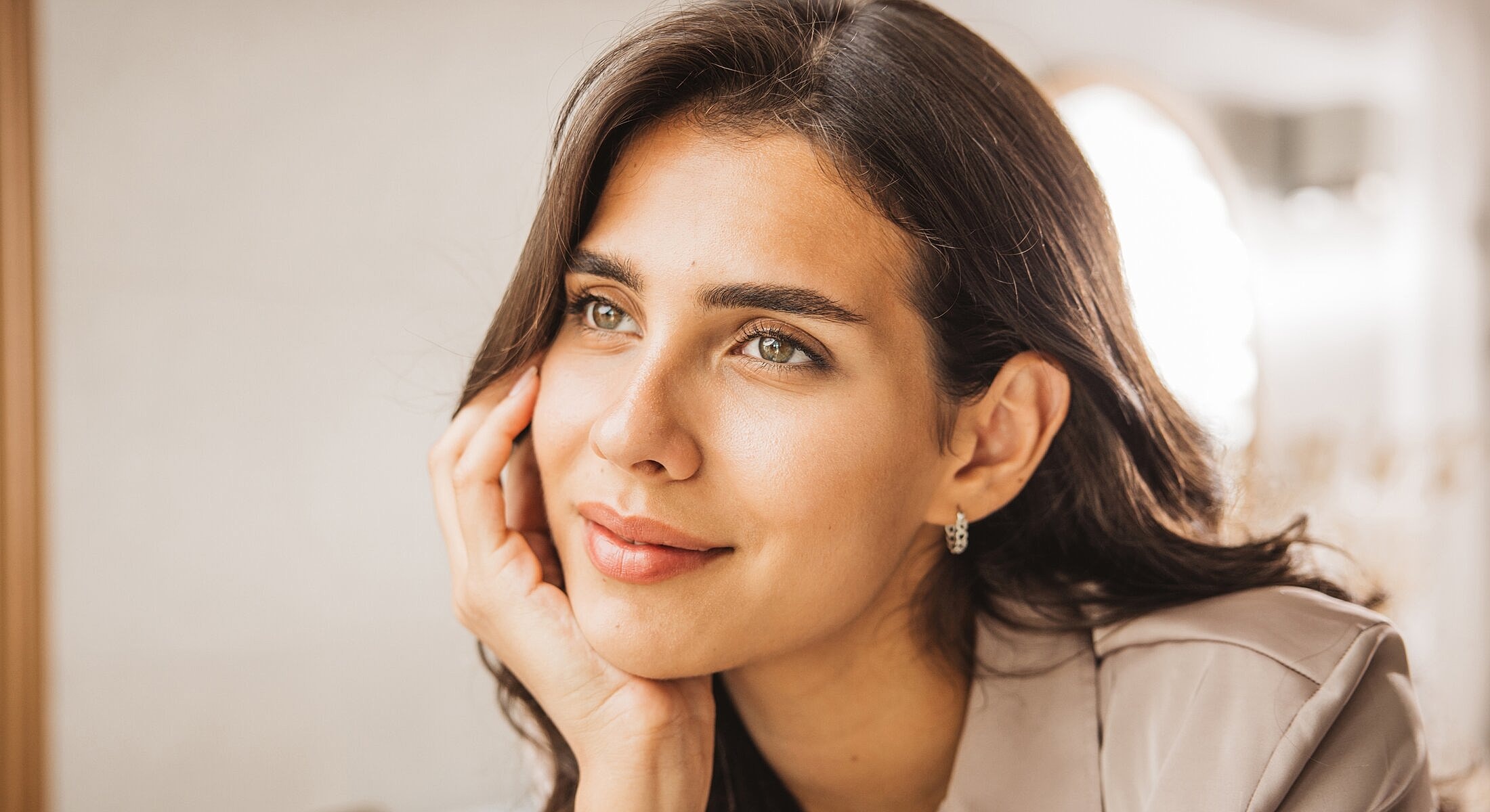 Thoughtful woman resting her chin on hand.
