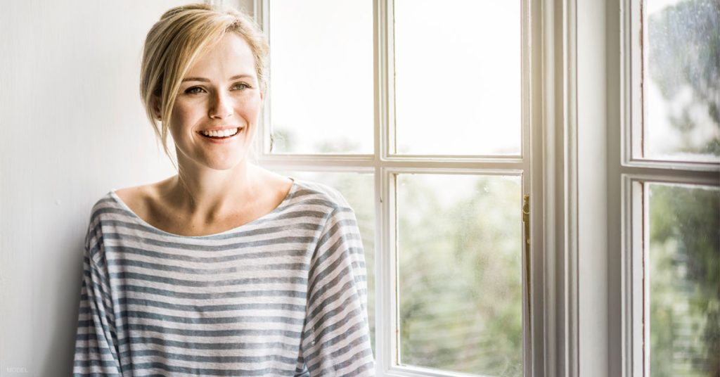 Woman smiling after recovering from eyelid surgery